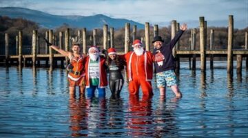 بملابس بابا نويل متطوعون في بريطانيا يتحدون برودة المياه لجمع